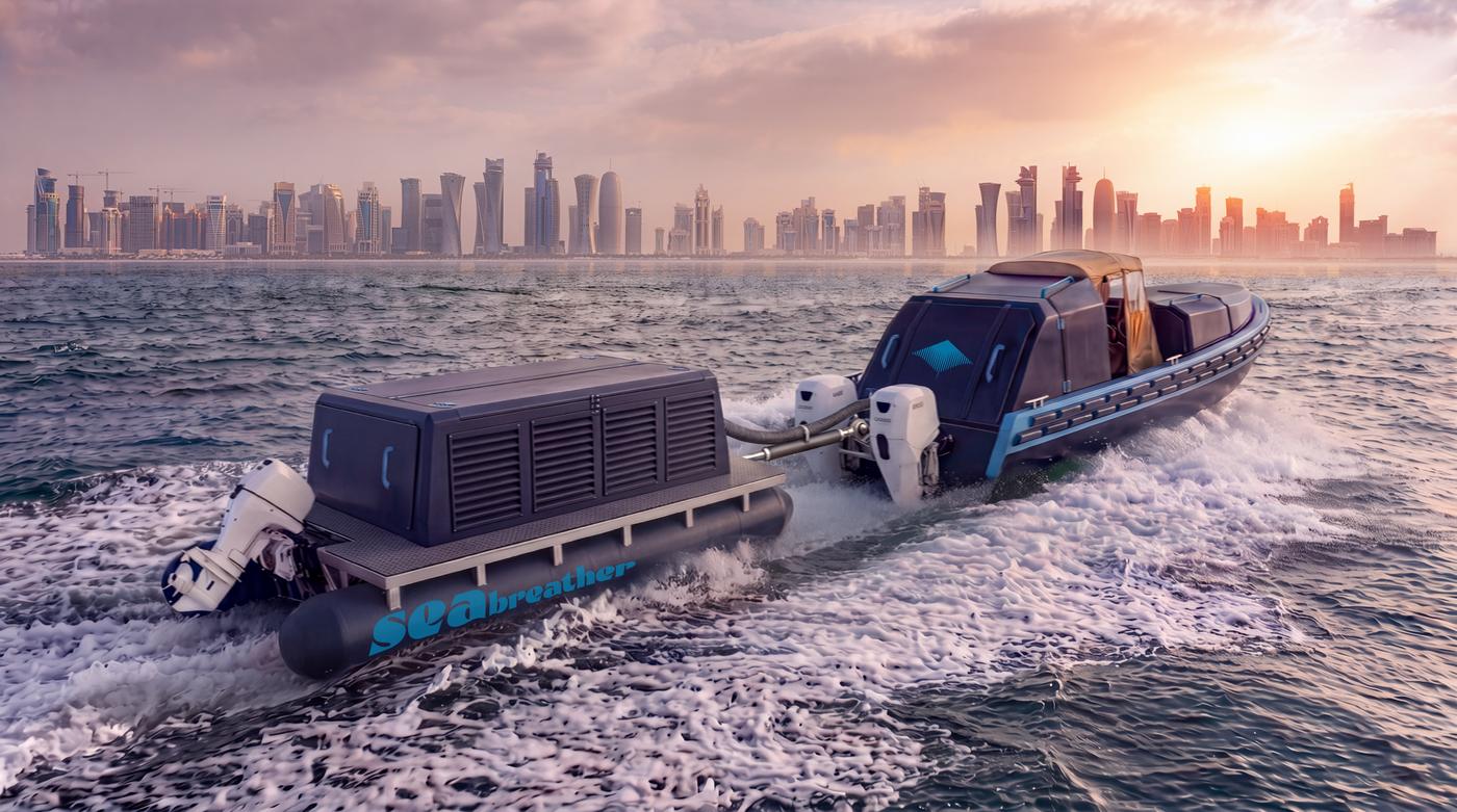 The paired hulls of a Super SeaBreather under way off Doha, the skyline behind them at sunset